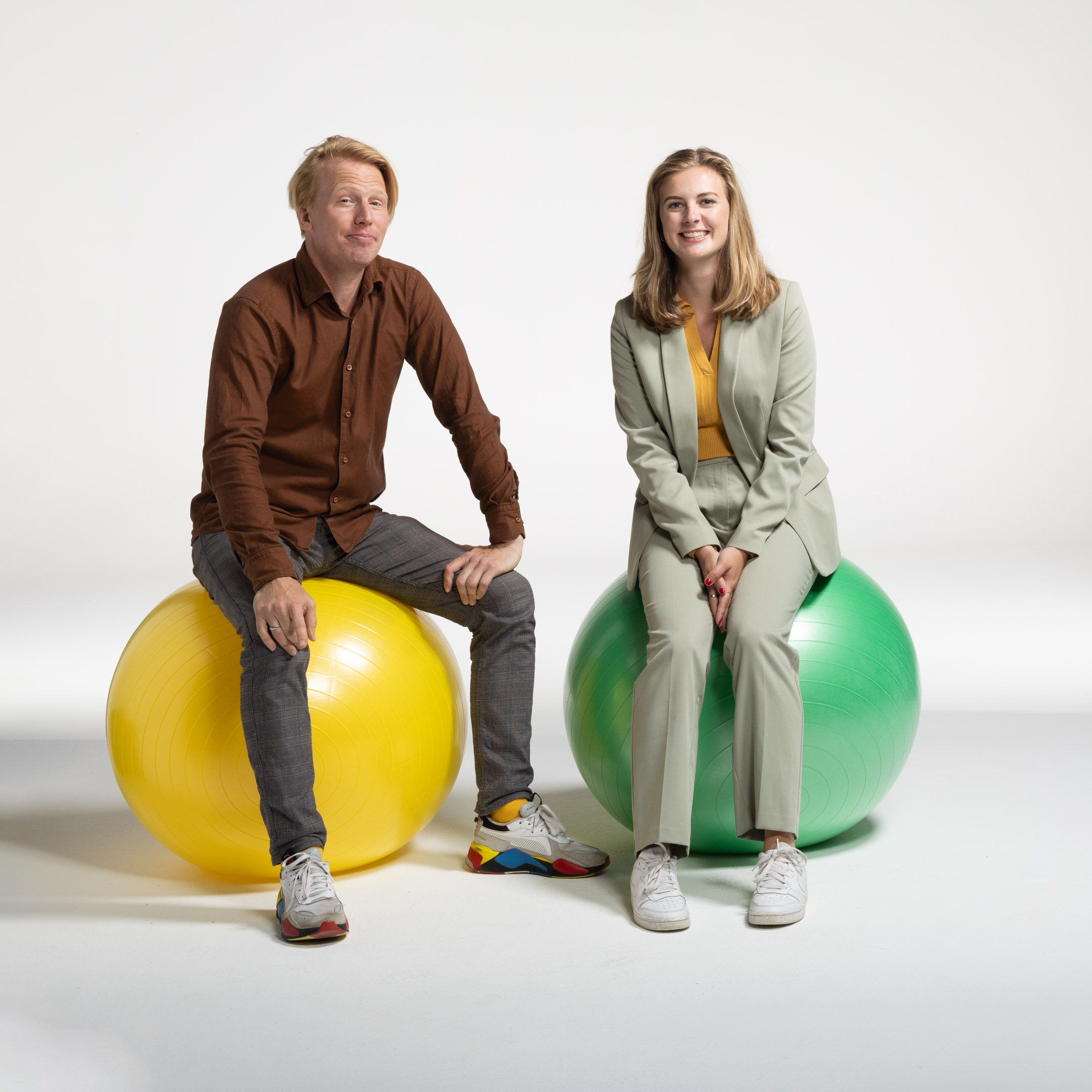 Twee mensen zitten op skippyballen