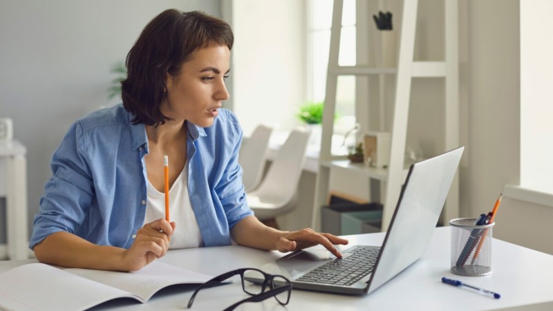 freelancer die op haar laptop kijkt en zoekt naar wat het verschil is tussen een crowdsurance en een traditionele AOV