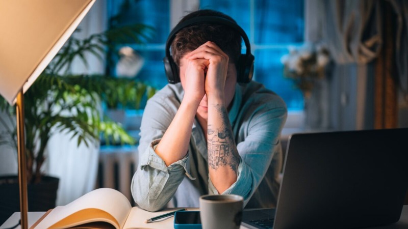 freelancer die vermoeid en met zorgen achter zijn laptop zit